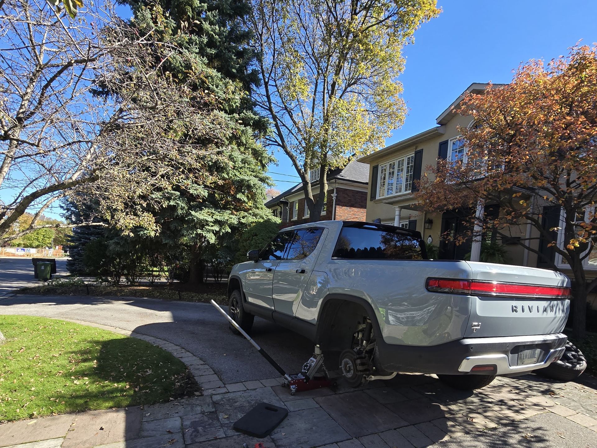 Rivian truck with its front wheel removed during a driveway tire service in the GTA
