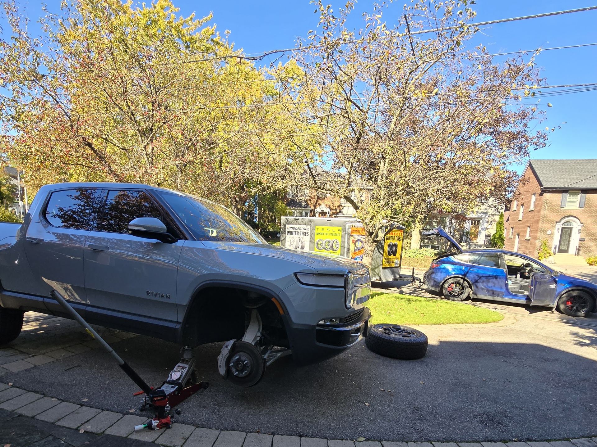 Rivian truck with its front wheel removed during a driveway tire service in the GTA