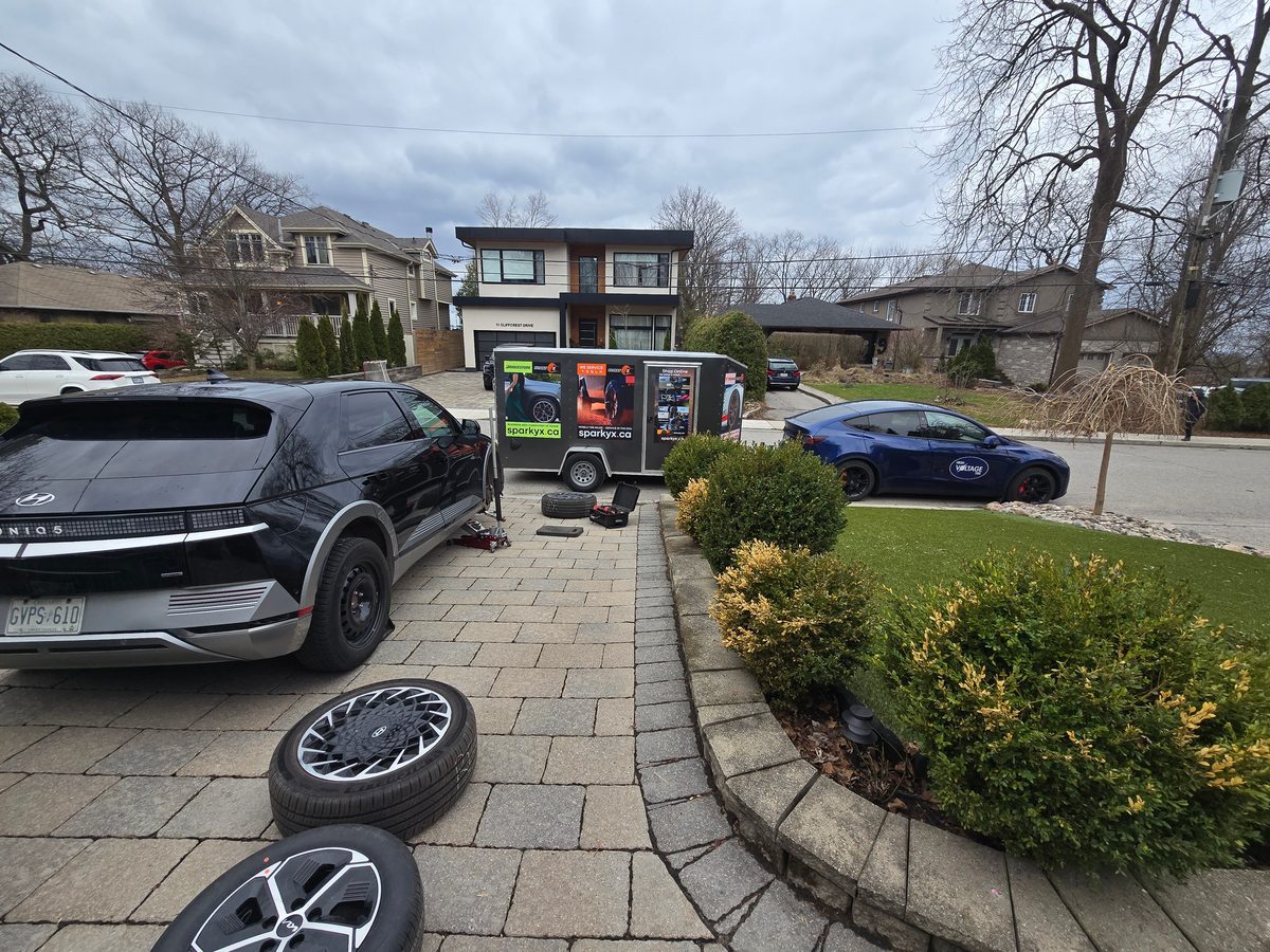 Black Hyundai IONIQ 5 during a driveway tire service, Sparky X trailer behind it